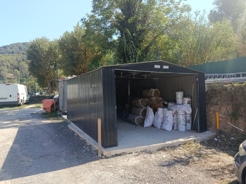 Dépôt atelier ouvert avec bois de charpente, sacs et pots stockés
